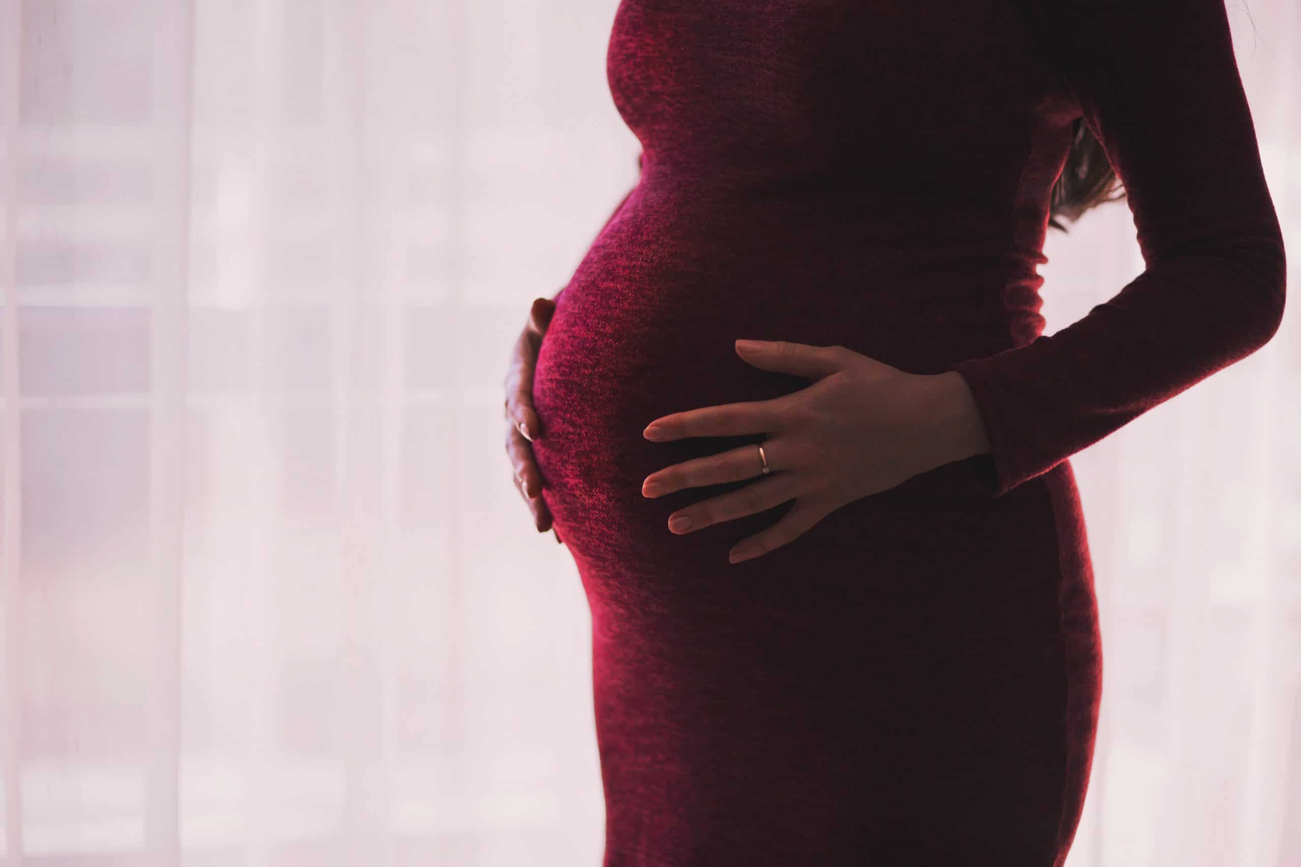 shot of a pregnant woman clutching her belly