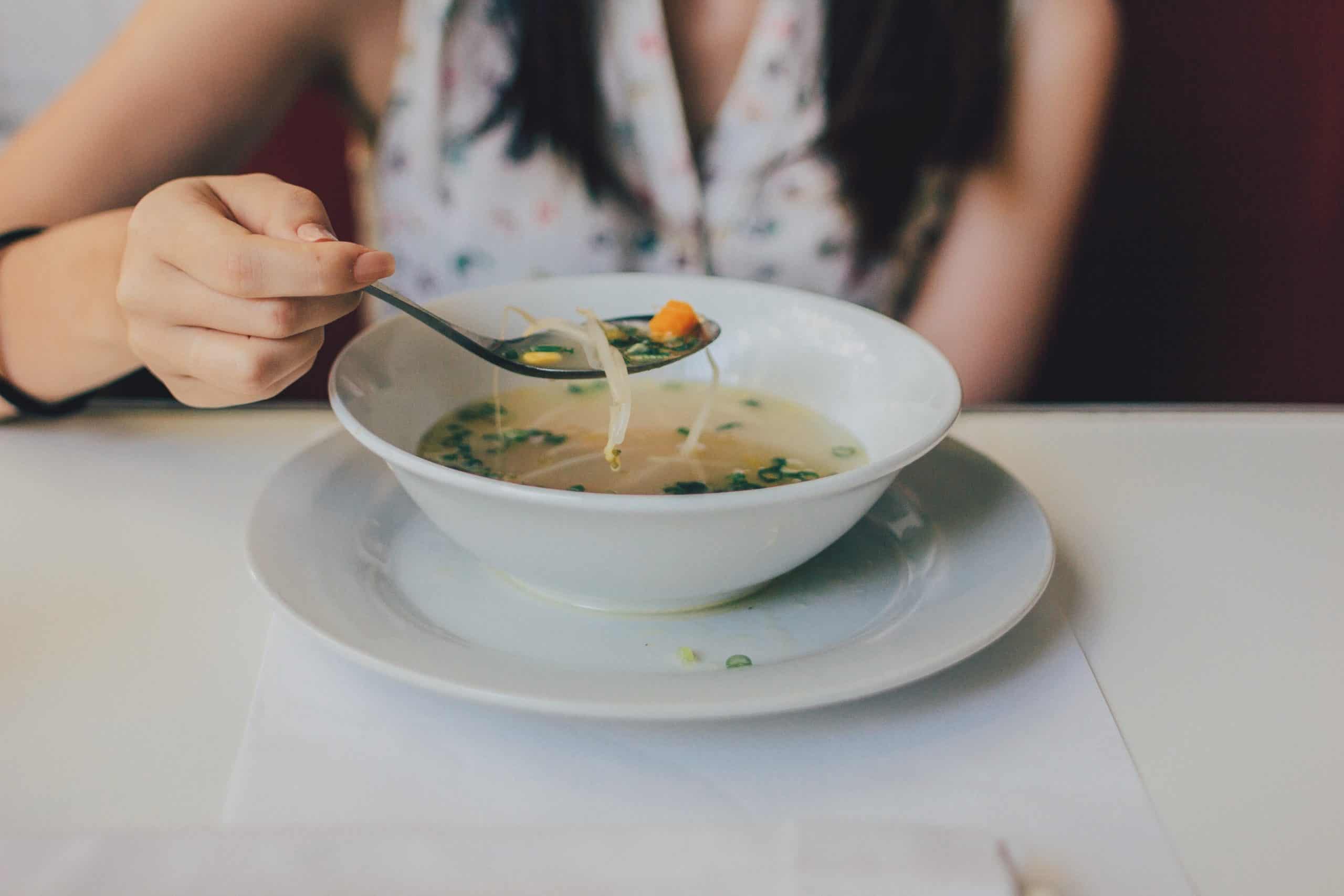 young asian woman with a bowl of soup noodles