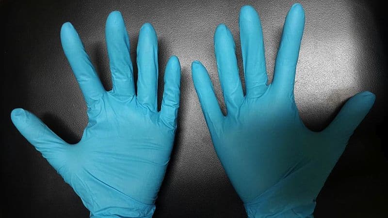 Protected nitrile gloves are worn in the hands of caretakers.