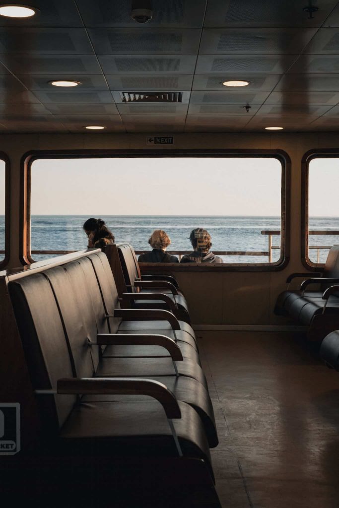 Calm view of sea from ship window with passengers seats and people on board