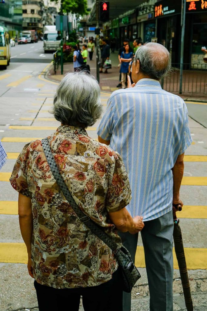 An elderly couple travelling together.