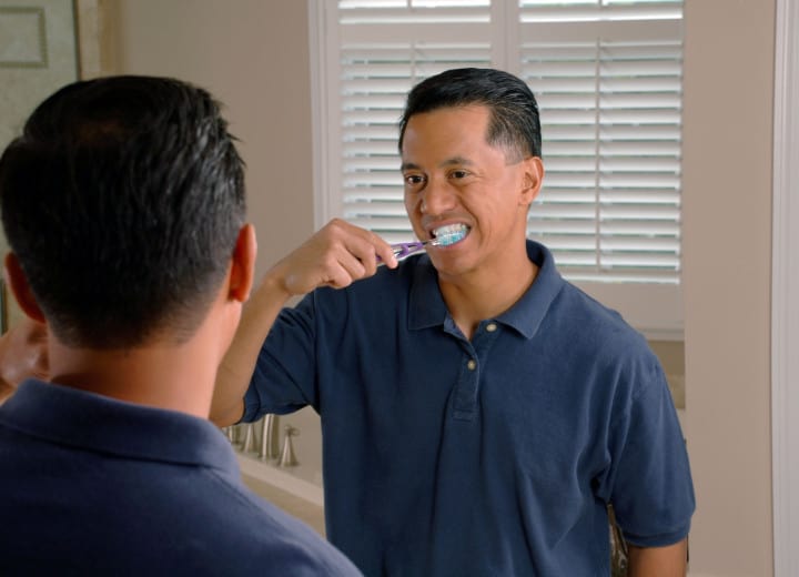 A senior brushing his teeth.