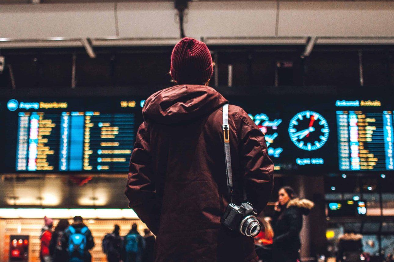 traveller looking at the board of flights at an airport