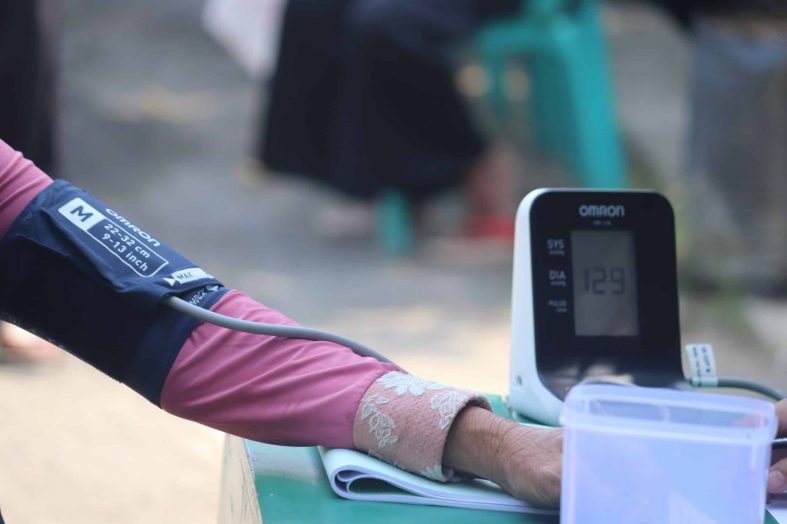 lady taking blood pressure with an omron blood pressure monitor and cuff outdoors