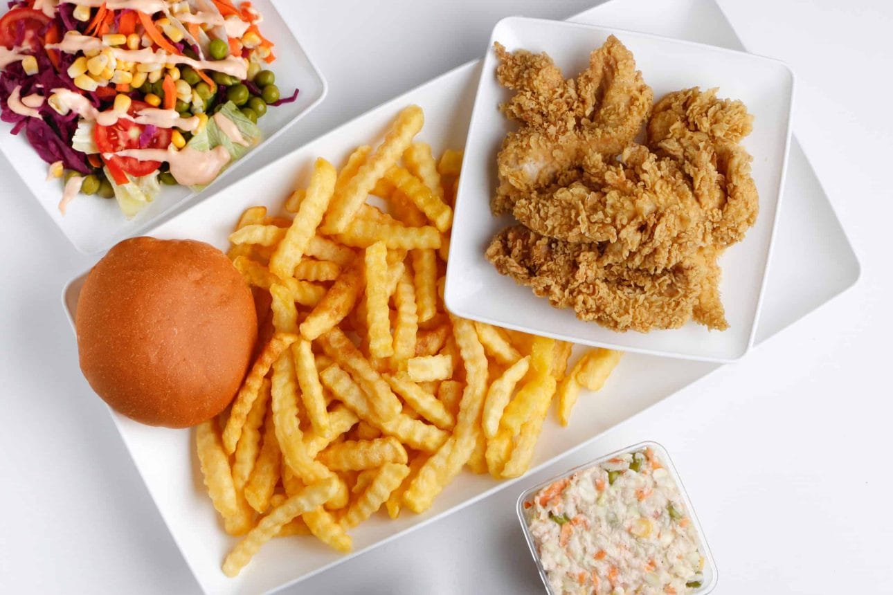 bun, french fries, fried chicken, and salad meal