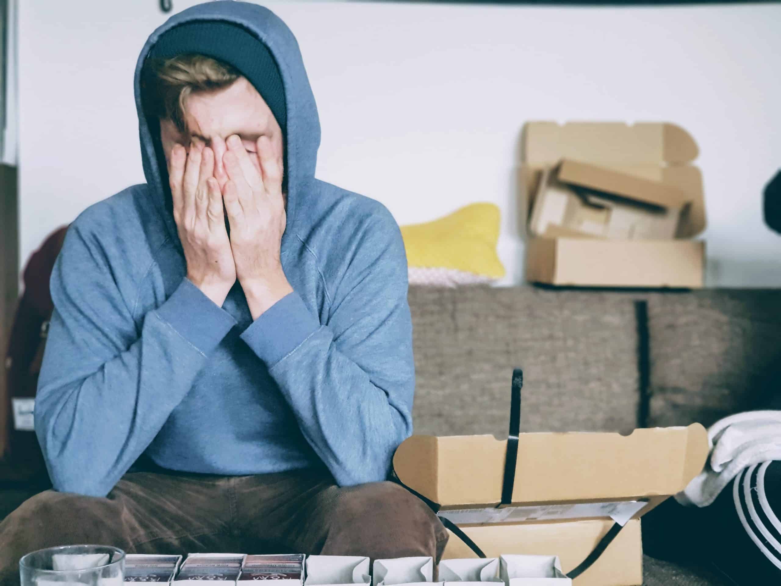 man in hoodie looking stressed