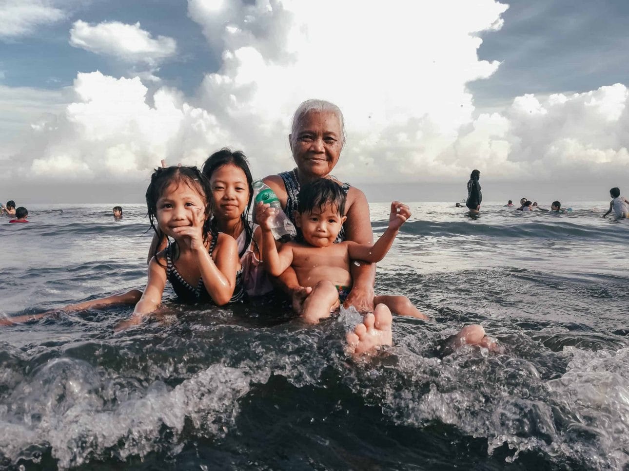 elderly grandmother with 3 grandchildren in the sea