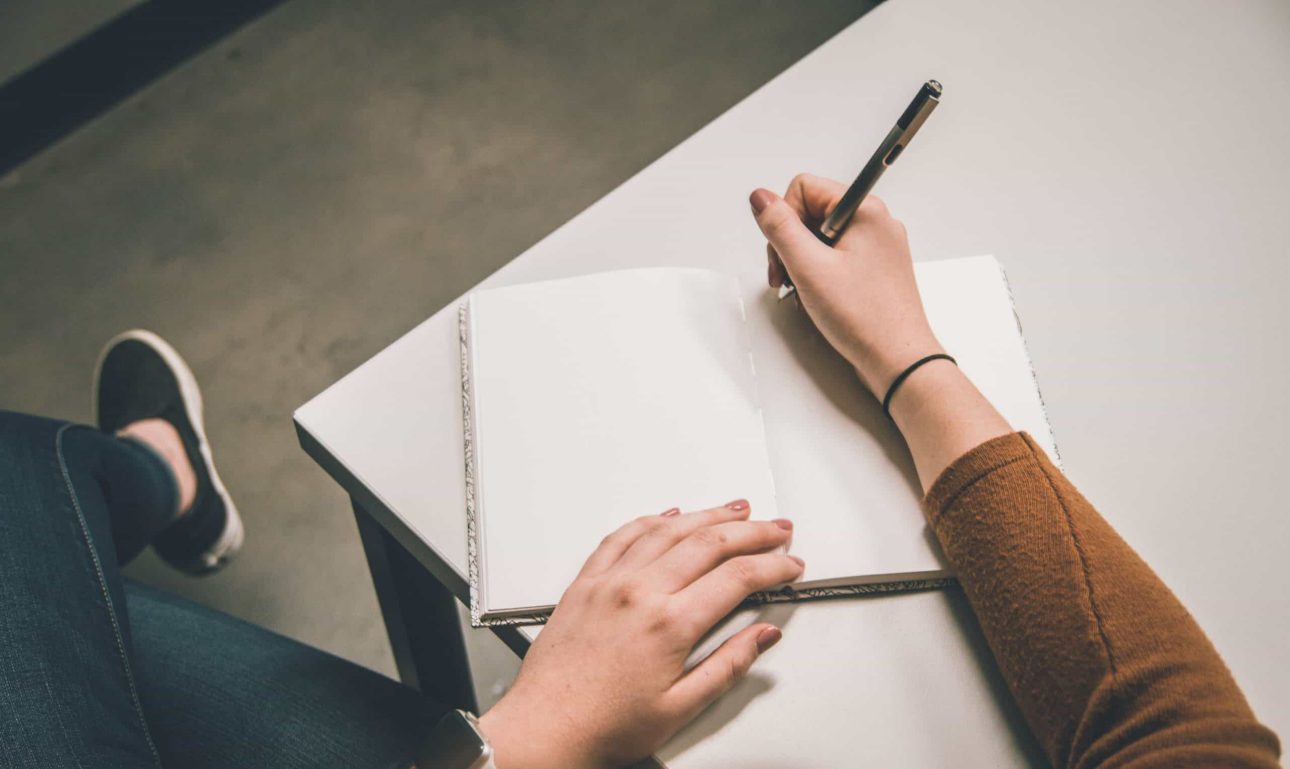 girl writing on a notebook