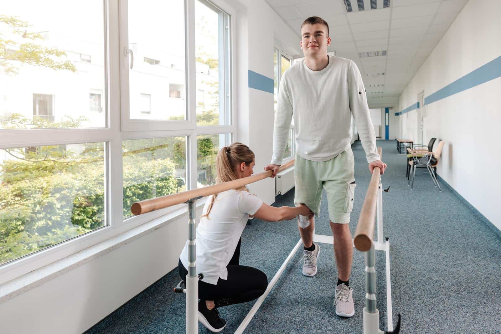 A young man is in a walking rehabilitation course after a sports injury on his knee.