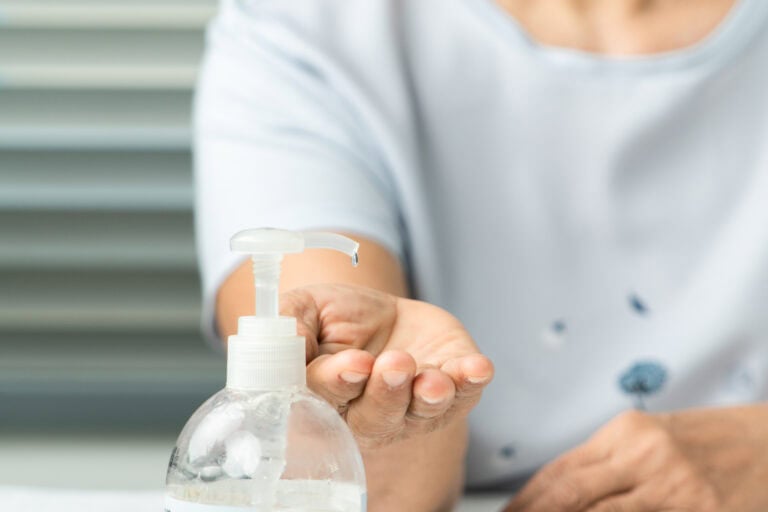 Senior hand apply alcohol gel or anti bacteria soap to make clea